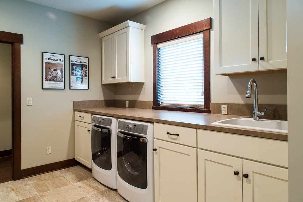 Inspiration for a traditional utility room in Portland with a side by side washer and dryer, shaker cabinets, white cabinets, laminate countertops, beige walls and a built-in sink.