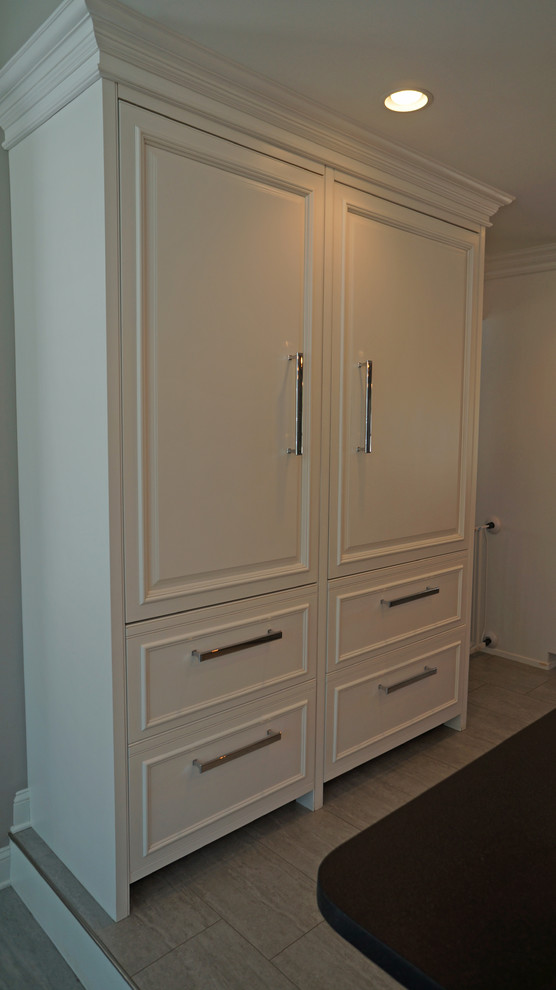 Photo of a large classic single-wall separated utility room in Philadelphia with a submerged sink, beaded cabinets, white cabinets, granite worktops, white walls, porcelain flooring and a side by side washer and dryer.