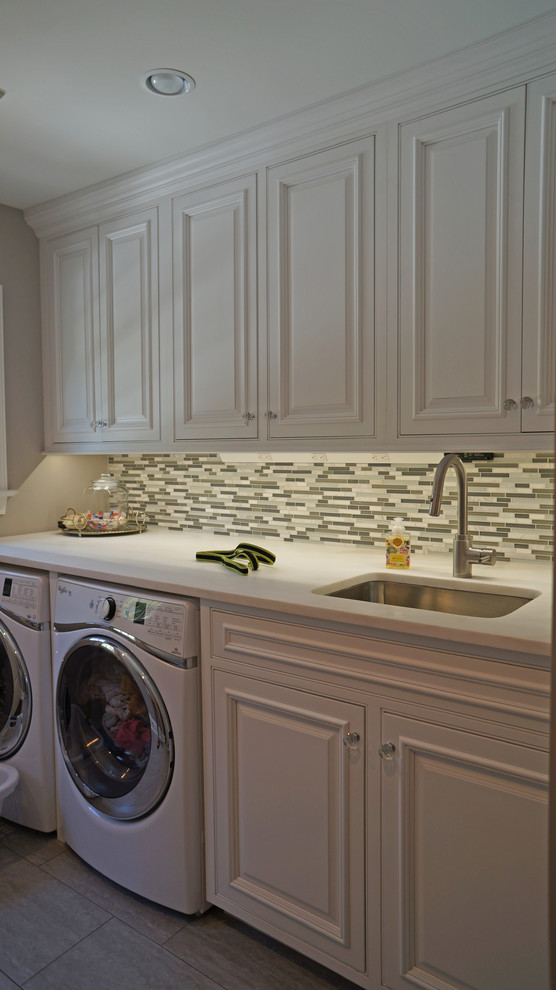 Dedicated laundry room - large traditional single-wall porcelain tile dedicated laundry room idea in Philadelphia with an undermount sink, beaded inset cabinets, white cabinets, granite countertops, white walls and a side-by-side washer/dryer