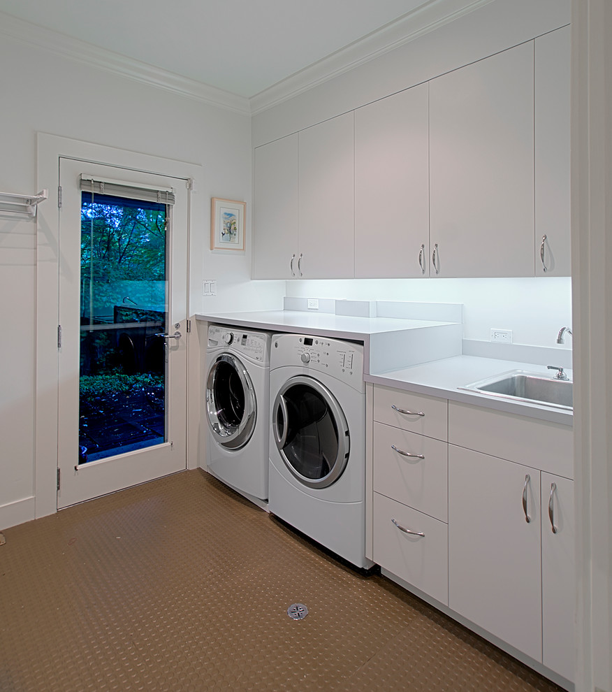 Immagine di una sala lavanderia classica di medie dimensioni con lavello da incasso, ante lisce, ante bianche, pareti bianche e lavatrice e asciugatrice affiancate