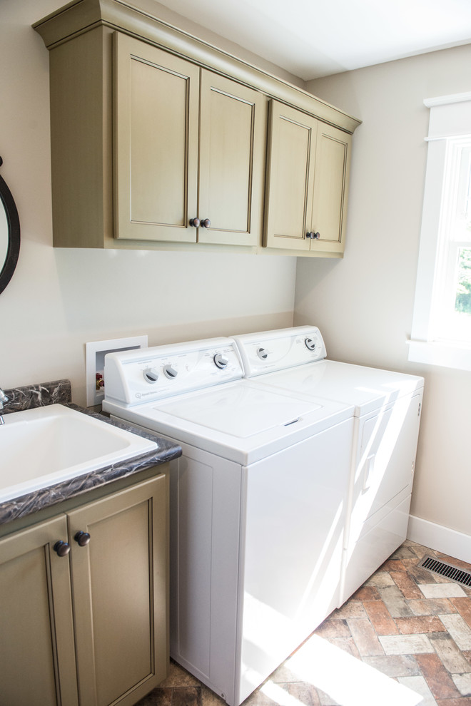 Example of a mid-sized country galley brick floor and multicolored floor dedicated laundry room design in Other with a drop-in sink, flat-panel cabinets, green cabinets, laminate countertops, gray walls and a side-by-side washer/dryer