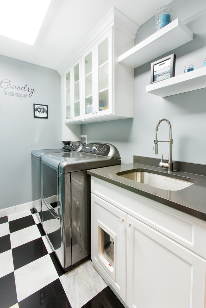 Immagine di una piccola sala lavanderia minimalista con lavello sottopiano, ante in stile shaker, ante bianche, top in superficie solida, pavimento in gres porcellanato, lavatrice e asciugatrice affiancate e pareti grigie