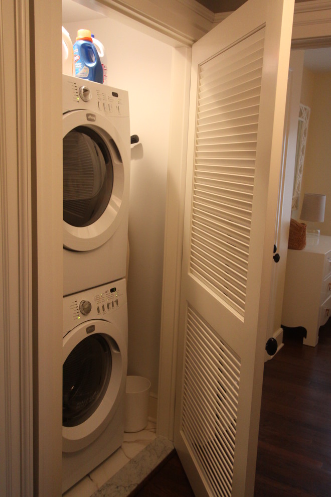 Kleiner Klassischer Hauswirtschaftsraum mit Waschmaschinenschrank und Waschmaschine und Trockner gestapelt in New York