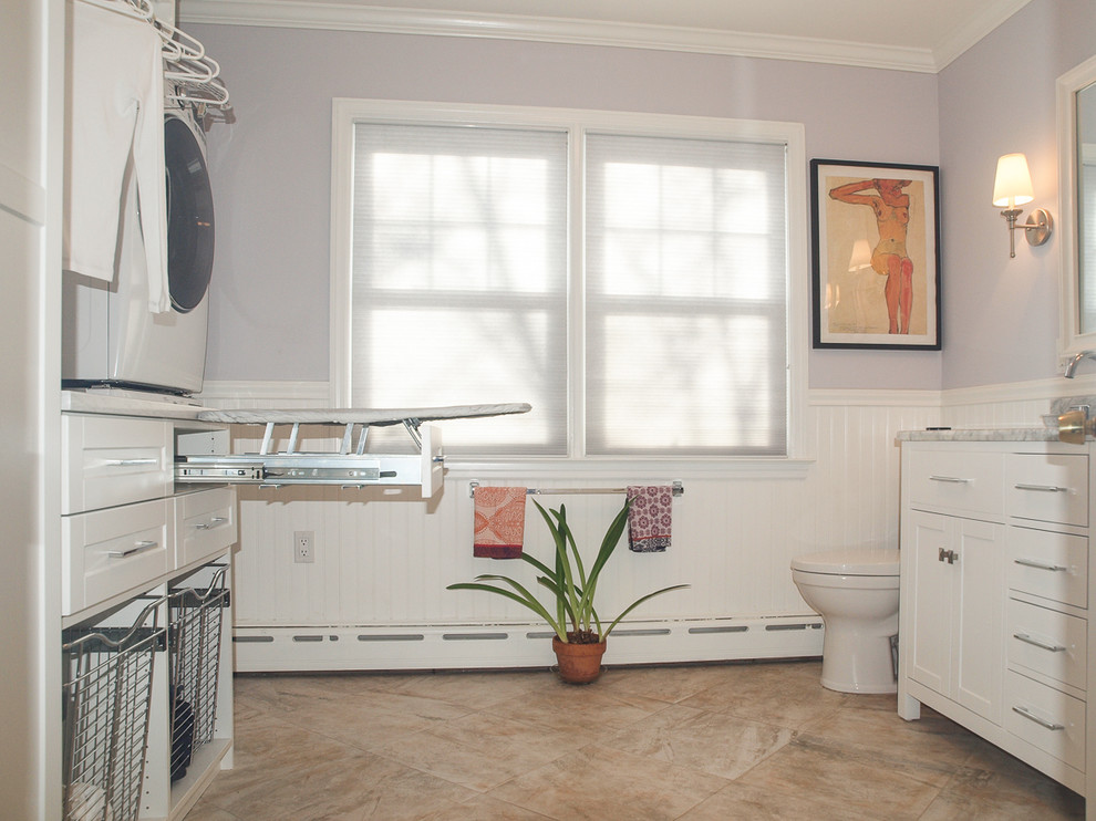 ニューヨークにあるお手頃価格の中くらいなコンテンポラリースタイルのおしゃれな家事室 (コの字型、アンダーカウンターシンク、シェーカースタイル扉のキャビネット、白いキャビネット、大理石カウンター、紫の壁、上下配置の洗濯機・乾燥機、磁器タイルの床) の写真