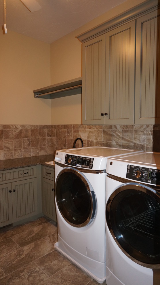 Immagine di una sala lavanderia country di medie dimensioni con top in granito, pavimento in gres porcellanato e lavatrice e asciugatrice affiancate