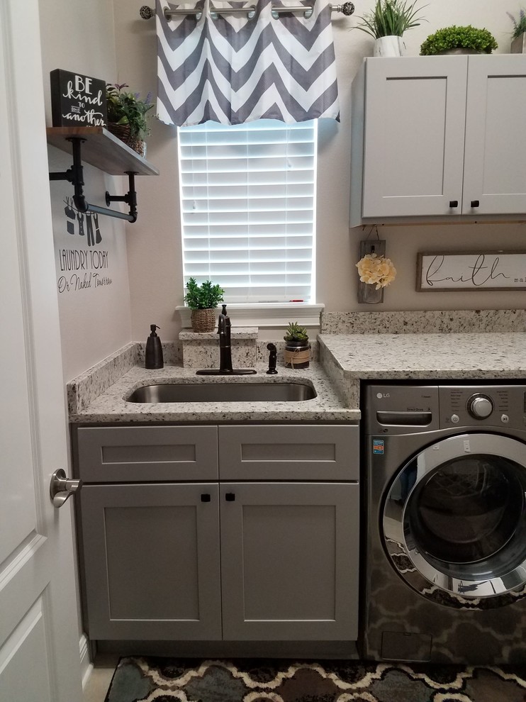 Foto di una lavanderia multiuso minimalista di medie dimensioni con lavello a vasca singola, ante in stile shaker, ante grigie, top in granito, pareti grigie, lavatrice e asciugatrice affiancate e top grigio