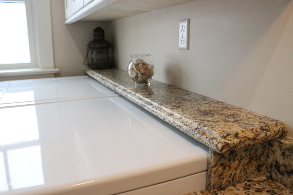 Exempel på en klassisk linjär tvättstuga enbart för tvätt, med en enkel diskho, skåp i shakerstil, vita skåp, granitbänkskiva, beige väggar, klinkergolv i porslin och en tvättmaskin och torktumlare bredvid varandra
