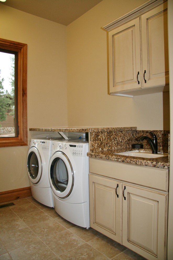 Foto på en rustik parallell tvättstuga enbart för tvätt, med en undermonterad diskho, luckor med upphöjd panel, beige skåp, granitbänkskiva, klinkergolv i keramik och en tvättmaskin och torktumlare bredvid varandra