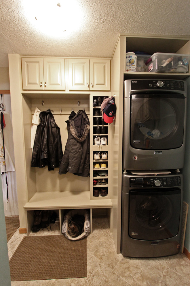 クリーブランドにある低価格の中くらいなトランジショナルスタイルのおしゃれな家事室 (I型、ドロップインシンク、レイズドパネル扉のキャビネット、ベージュのキャビネット、緑の壁、上下配置の洗濯機・乾燥機) の写真