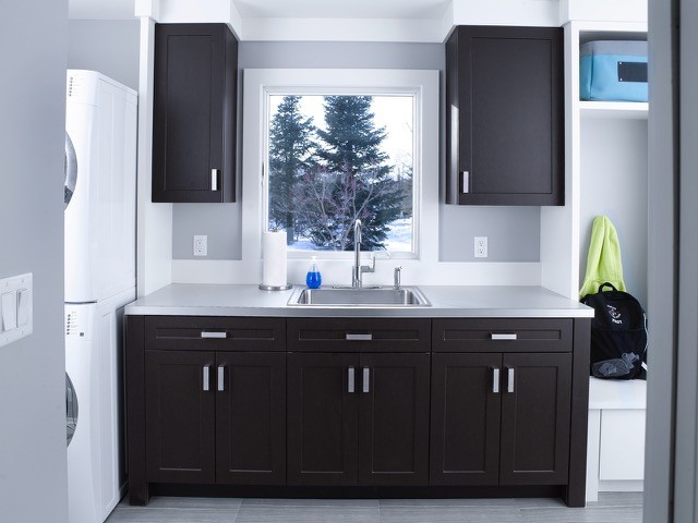 Design ideas for a large contemporary u-shaped utility room in New York with flat-panel cabinets, white cabinets, white splashback and dark hardwood flooring.