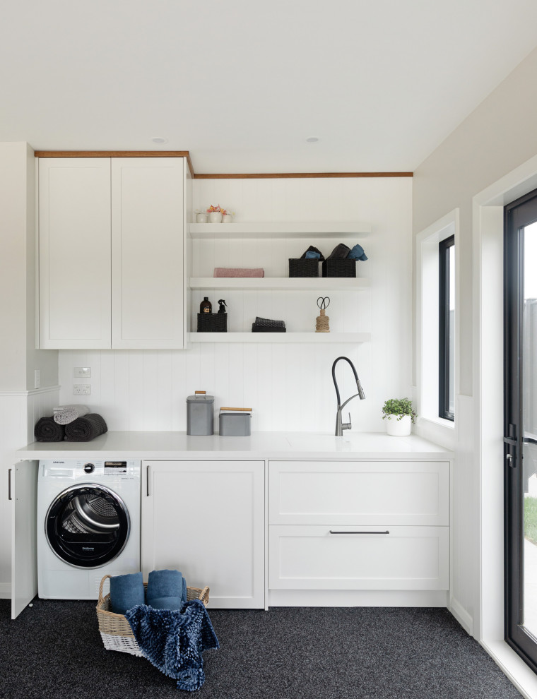 Photo of a medium sized contemporary single-wall utility room in Auckland with a submerged sink, shaker cabinets, white cabinets, quartz worktops, white splashback, wood splashback, white walls, carpet, an integrated washer and dryer, grey floors, white worktops, a vaulted ceiling and tongue and groove walls.