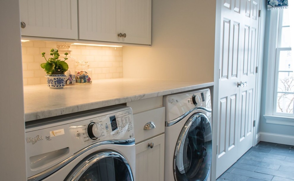 Example of a small classic galley gray floor utility room design in Cleveland with a drop-in sink, white cabinets, white walls and a side-by-side washer/dryer