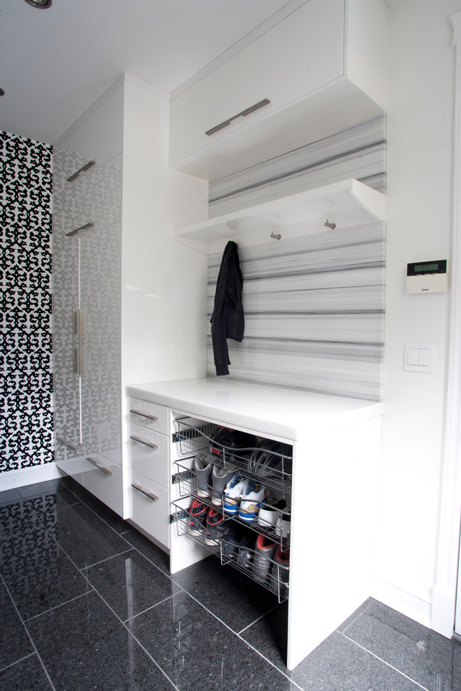 Utility room - mid-sized contemporary galley ceramic tile utility room idea in Calgary with flat-panel cabinets, white cabinets, marble countertops, multicolored walls and a side-by-side washer/dryer