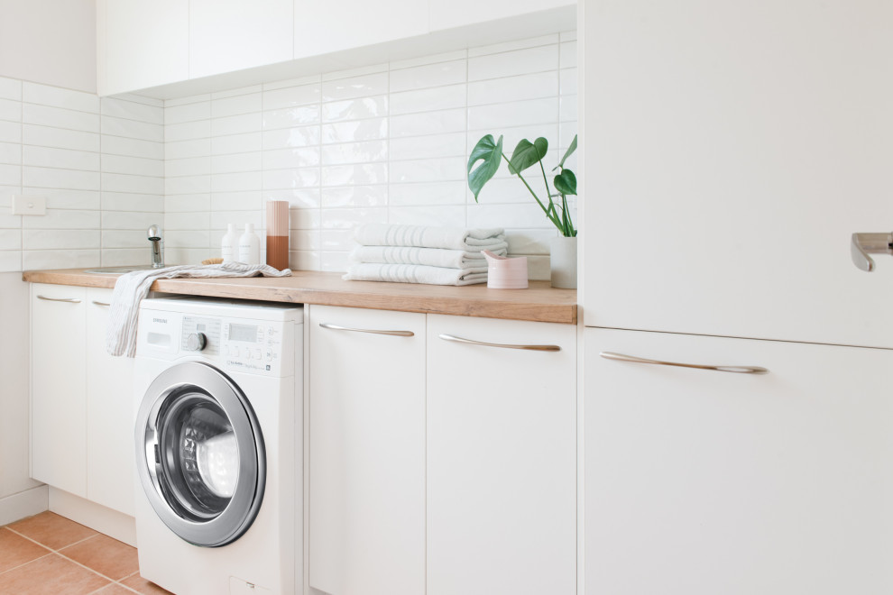 Inspiration for a mid-sized scandinavian galley terra-cotta tile dedicated laundry room remodel in Melbourne with a drop-in sink, open cabinets, white cabinets, laminate countertops, white walls and a side-by-side washer/dryer