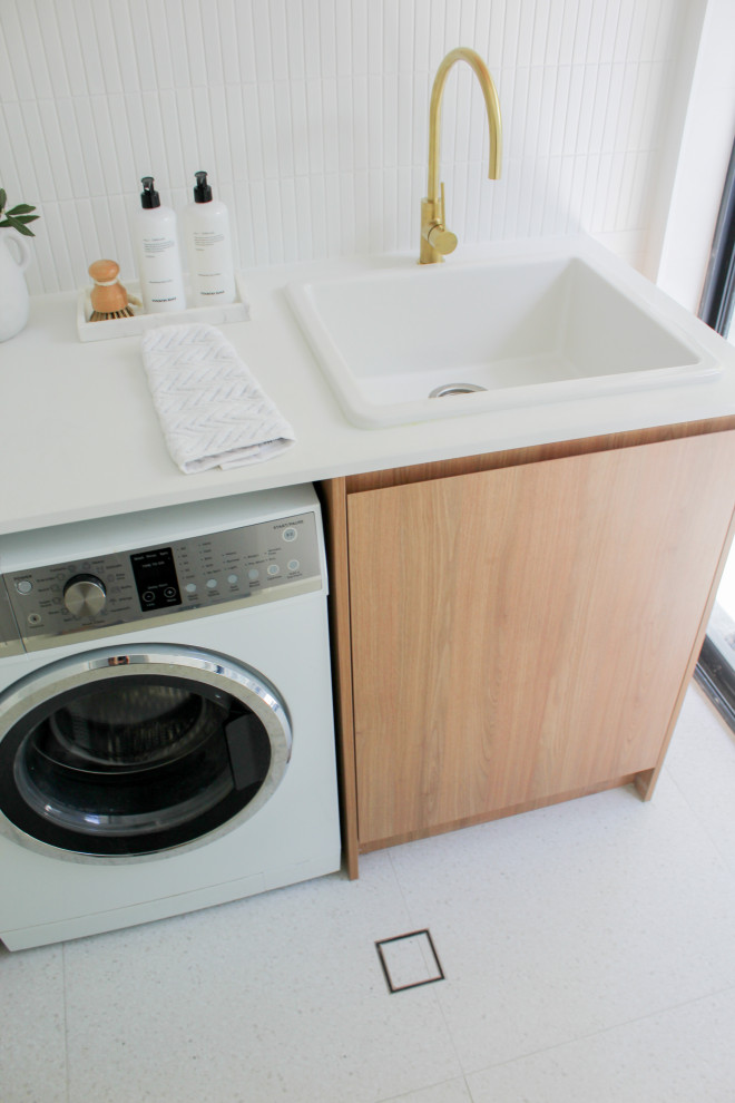 Example of a mid-sized farmhouse single-wall porcelain tile and multicolored floor dedicated laundry room design in Perth with a farmhouse sink, flat-panel cabinets, dark wood cabinets, quartz countertops, white walls, a side-by-side washer/dryer and white countertops