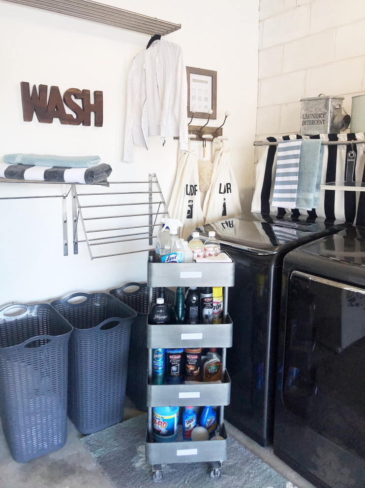 Modelo de cuarto de lavado en L contemporáneo pequeño con paredes blancas, suelo de cemento y lavadora y secadora juntas