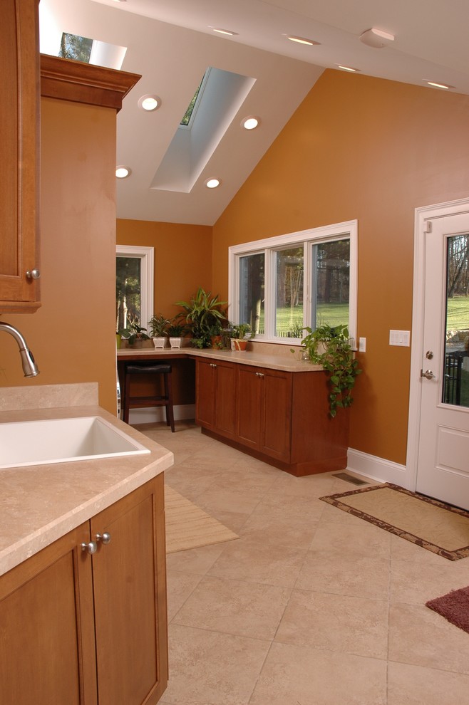 Design ideas for a traditional single-wall utility room in Cincinnati with a built-in sink, recessed-panel cabinets, medium wood cabinets, laminate countertops, orange walls, lino flooring and a side by side washer and dryer.