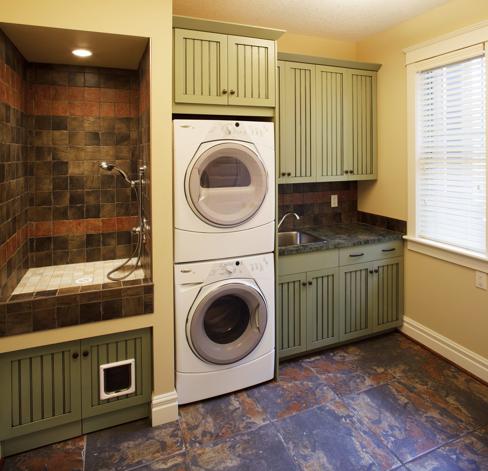 フェニックスにあるお手頃価格の小さなエクレクティックスタイルのおしゃれな家事室 (I型、ドロップインシンク、落し込みパネル扉のキャビネット、緑のキャビネット、ラミネートカウンター、ベージュの壁、スレートの床、上下配置の洗濯機・乾燥機) の写真