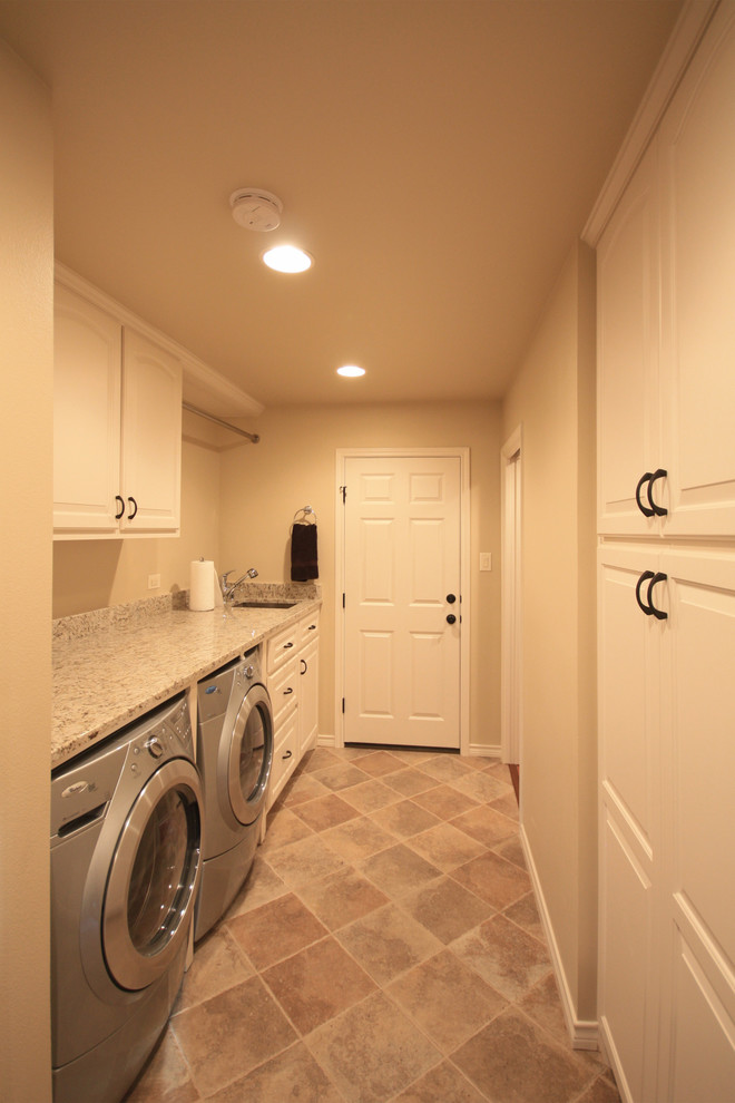 Laundry room - mid-sized traditional single-wall porcelain tile laundry room idea in Austin with an undermount sink, raised-panel cabinets, white cabinets, beige walls and a side-by-side washer/dryer