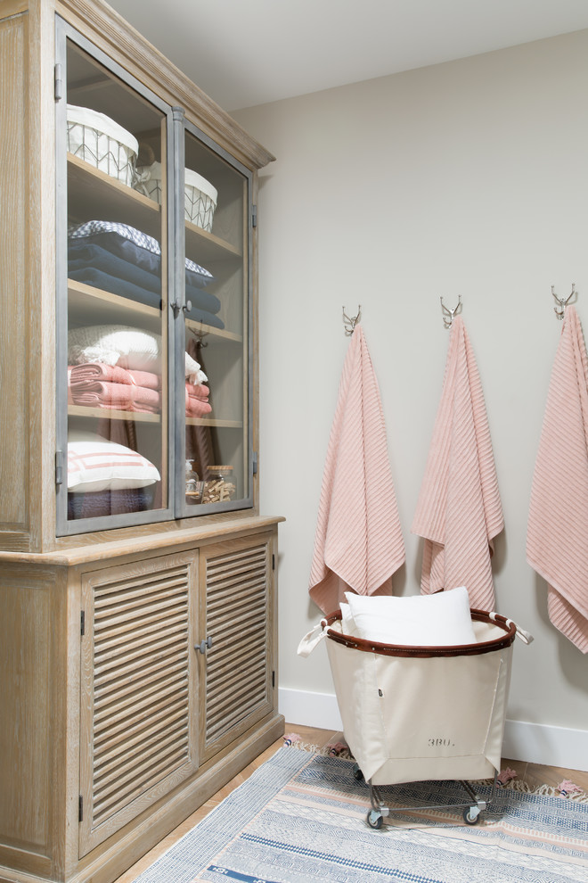 Idee per una piccola sala lavanderia tradizionale con ante di vetro, pareti beige, pavimento con piastrelle in ceramica, pavimento beige e ante in legno scuro