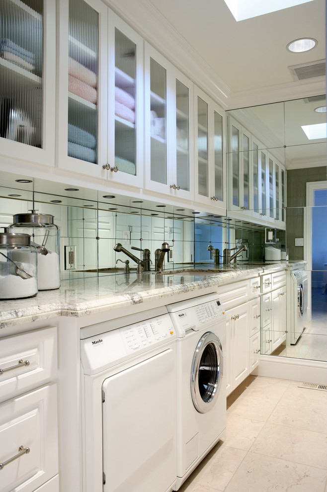Example of a mid-sized transitional single-wall marble floor dedicated laundry room design in San Francisco with an undermount sink, raised-panel cabinets, white cabinets, granite countertops and a side-by-side washer/dryer