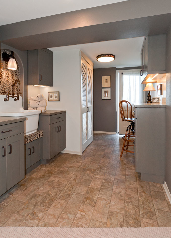Inspiration for a small craftsman galley vinyl floor utility room remodel in Seattle with a farmhouse sink, shaker cabinets, gray cabinets, laminate countertops, gray walls and a stacked washer/dryer