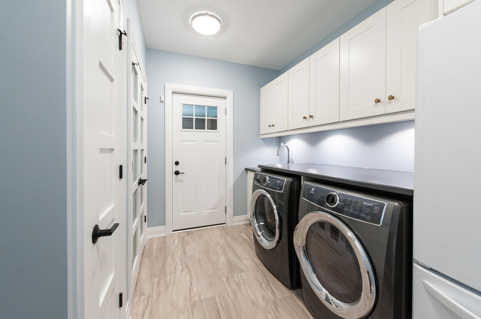 Idee per una sala lavanderia chic di medie dimensioni con pareti blu, lavello da incasso, ante in stile shaker, ante bianche, top in laminato, pavimento in gres porcellanato, lavatrice e asciugatrice affiancate e pavimento beige