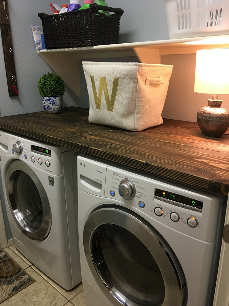 Idee per una piccola sala lavanderia country con top in legno, pareti blu, pavimento con piastrelle in ceramica e lavatrice e asciugatrice affiancate