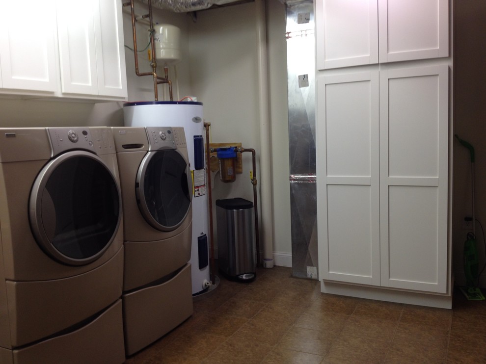 Example of a large classic u-shaped porcelain tile dedicated laundry room design in Charlotte with an undermount sink, shaker cabinets, white cabinets, laminate countertops, white walls and a side-by-side washer/dryer