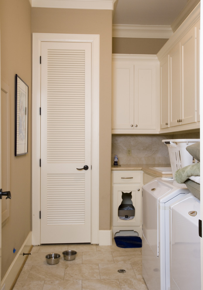 Example of a mid-sized eclectic l-shaped ceramic tile dedicated laundry room design in Houston with a drop-in sink, shaker cabinets, white cabinets, solid surface countertops, beige walls and a side-by-side washer/dryer