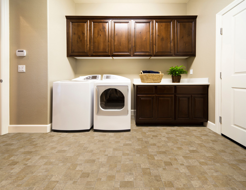 Utility room - mid-sized traditional single-wall vinyl floor utility room idea in Manchester with raised-panel cabinets, dark wood cabinets, beige walls and a side-by-side washer/dryer