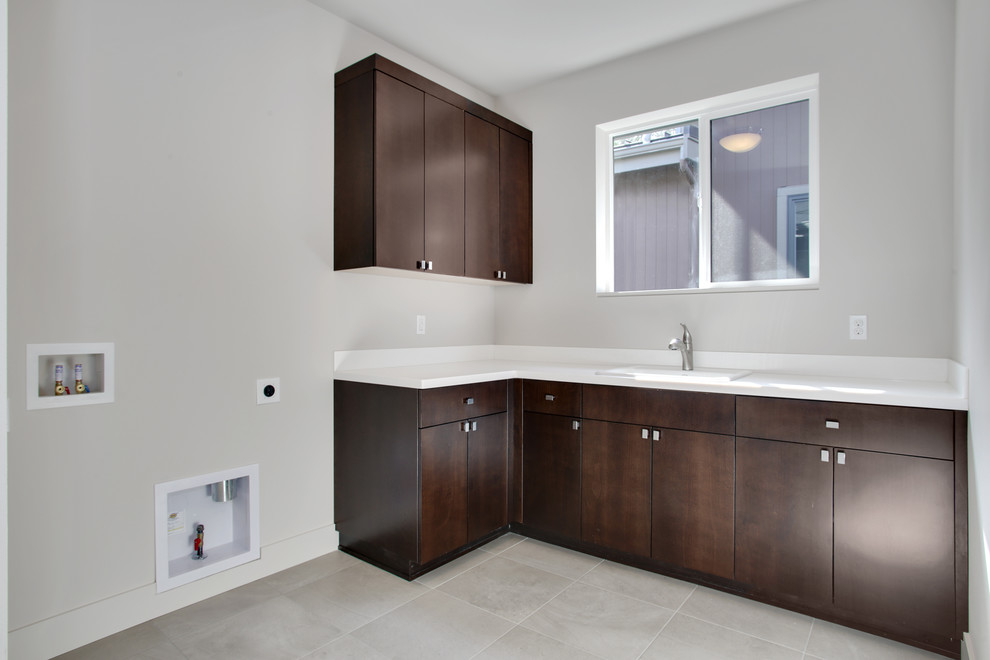 Contemporary l-shaped separated utility room in Seattle with a built-in sink, flat-panel cabinets, dark wood cabinets, composite countertops, grey walls, porcelain flooring and a side by side washer and dryer.