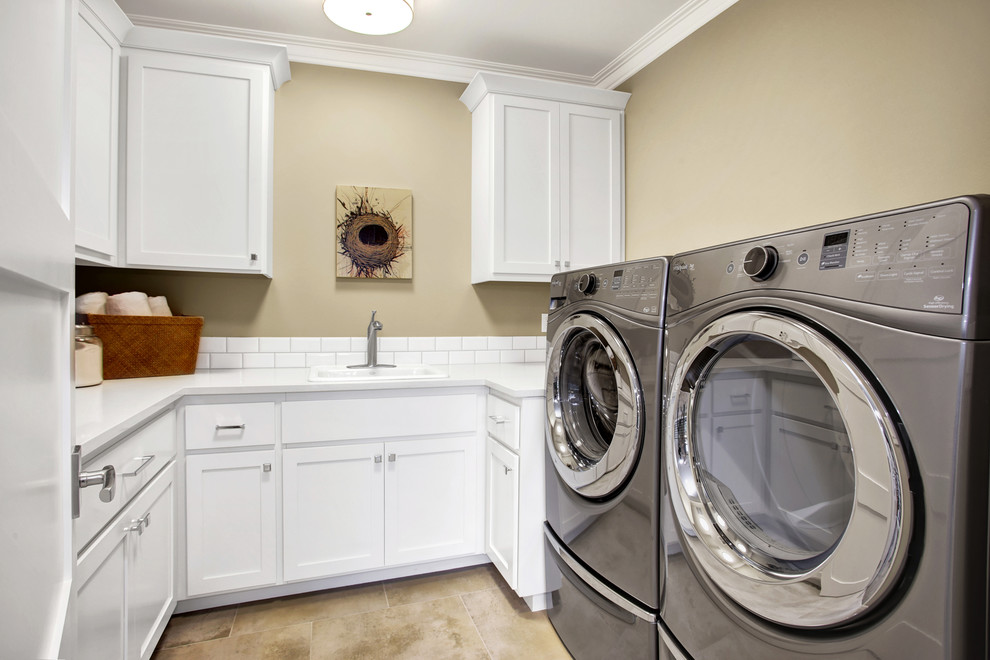 Idéer för att renovera en amerikansk u-formad tvättstuga enbart för tvätt, med en allbänk, skåp i shakerstil, vita skåp, bänkskiva i kvarts, beige väggar, klinkergolv i porslin och en tvättmaskin och torktumlare bredvid varandra