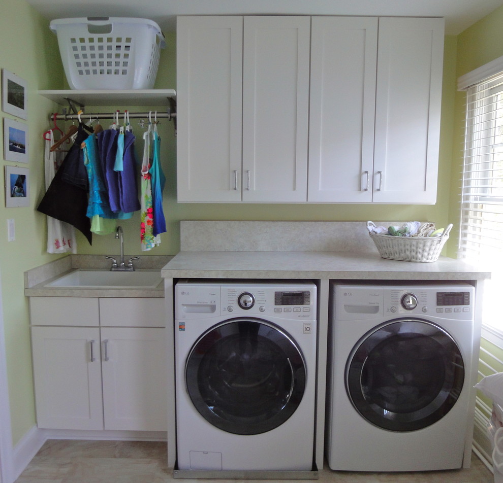 Bild på en mellanstor vintage parallell tvättstuga enbart för tvätt, med skåp i shakerstil, laminatbänkskiva, klinkergolv i keramik, en tvättmaskin och torktumlare bredvid varandra, en nedsänkt diskho, vita skåp och gröna väggar