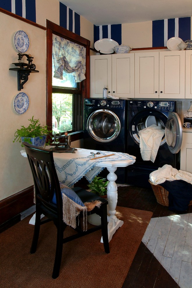 Immagine di un'ampia lavanderia multiuso classica con ante lisce, ante bianche, top in laminato, pareti beige, pavimento in legno verniciato e lavatrice e asciugatrice affiancate