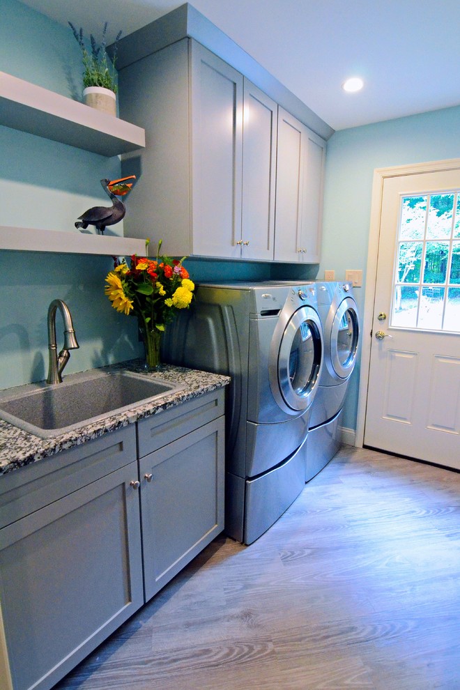Idee per una lavanderia multiuso tradizionale di medie dimensioni con lavello da incasso, ante in stile shaker, ante grigie, top in granito, pareti blu, pavimento in vinile, lavatrice e asciugatrice affiancate e pavimento grigio