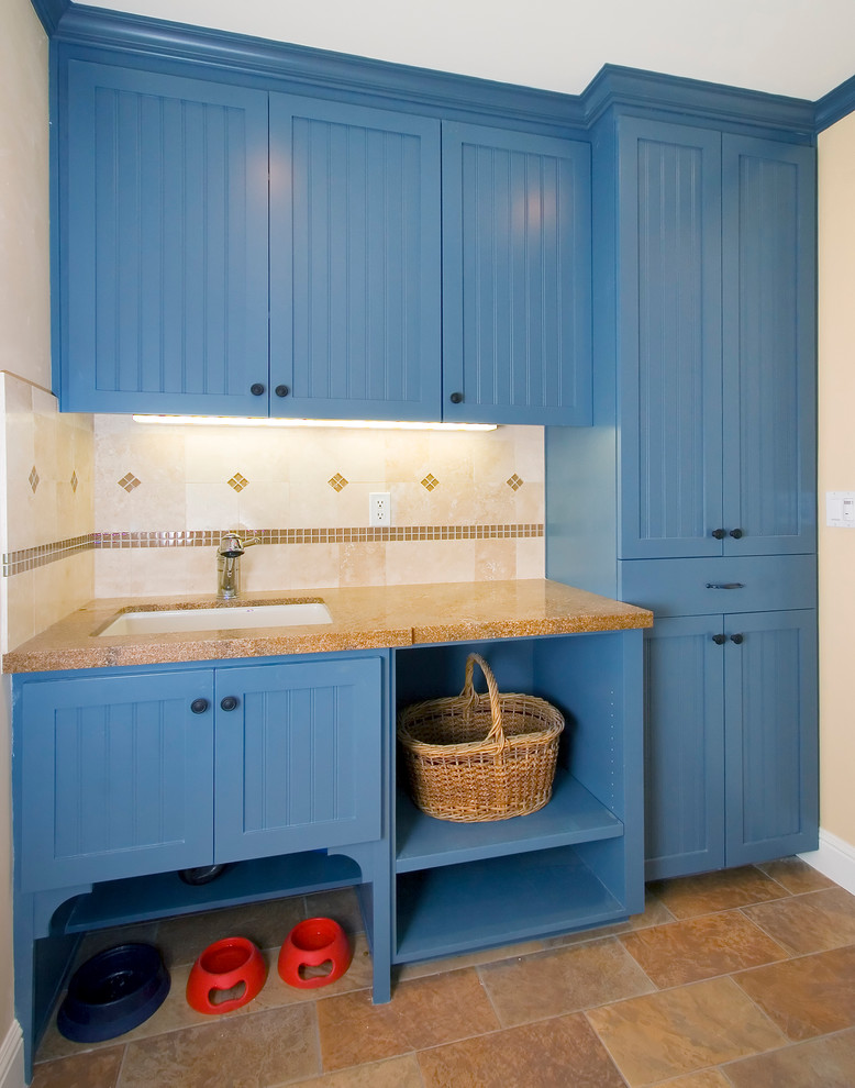 Foto di una lavanderia multiuso tradizionale di medie dimensioni con ante blu, lavello sottopiano, ante in stile shaker, top in granito, pareti beige, pavimento in gres porcellanato, pavimento beige e lavatrice e asciugatrice nascoste