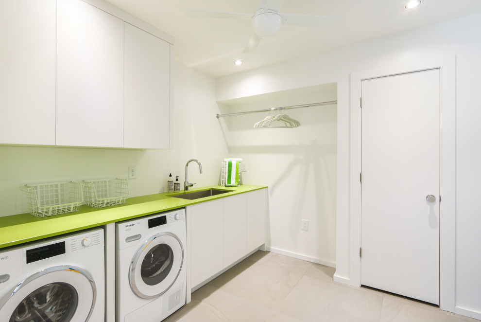 Inredning av en modern liten gröna linjär grönt tvättstuga enbart för tvätt, med en undermonterad diskho, släta luckor, vita skåp, bänkskiva i koppar, vita väggar, skiffergolv, en tvättmaskin och torktumlare bredvid varandra och beiget golv