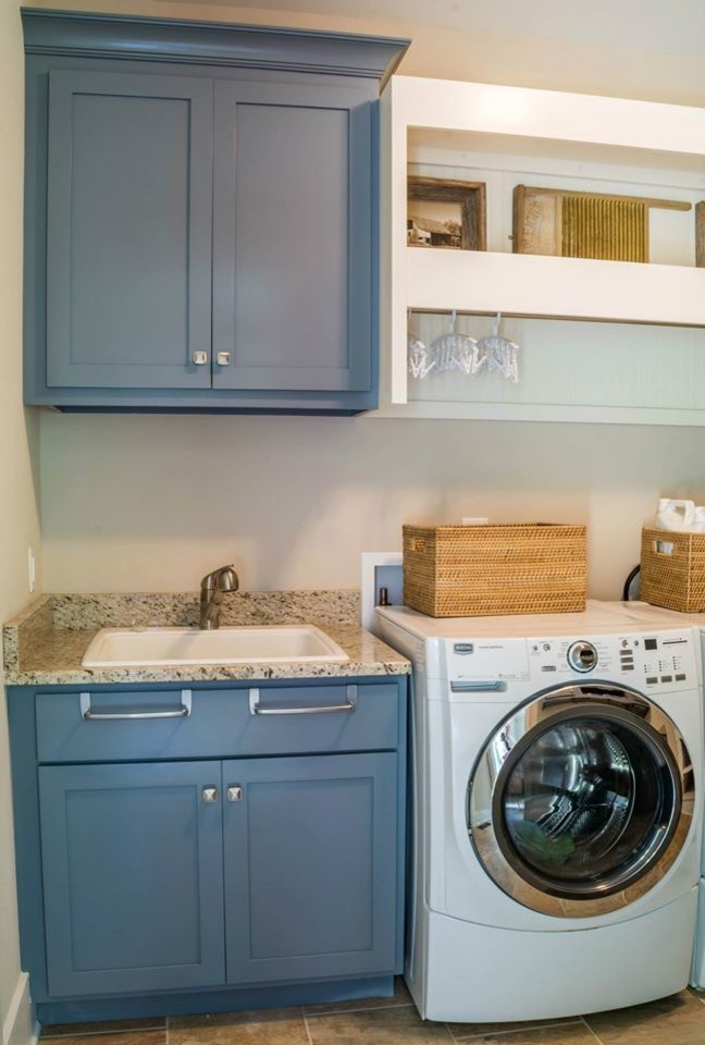 Foto di una lavanderia con ante blu, lavatrice e asciugatrice affiancate e top in granito