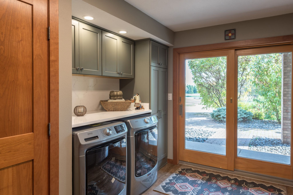 Example of a mid-sized transitional galley linoleum floor and brown floor laundry room design in Minneapolis with an undermount sink, shaker cabinets, gray cabinets, quartzite countertops, white backsplash, stone slab backsplash and white countertops