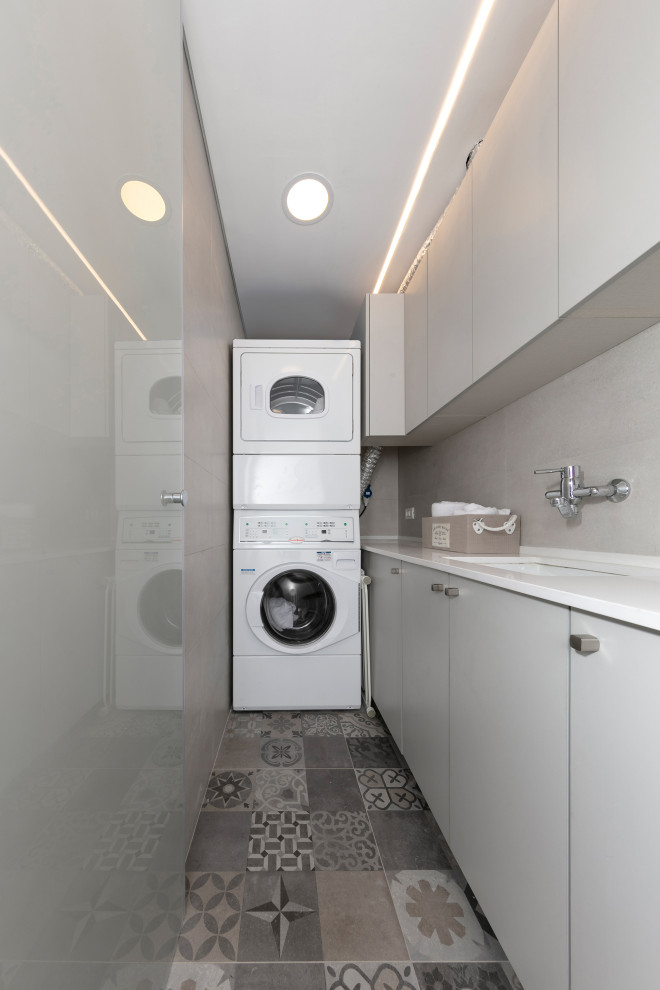 Moderne Waschküche in L-Form mit flächenbündigen Schrankfronten