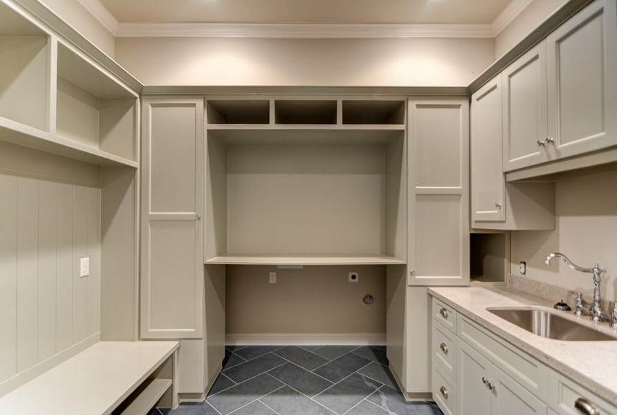This is an example of a large classic u-shaped utility room in Austin with a submerged sink, shaker cabinets, beige cabinets, limestone worktops, beige walls, slate flooring and a side by side washer and dryer.