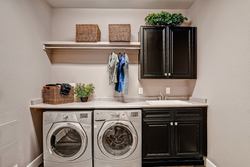 Klassischer Hauswirtschaftsraum mit schwarzen Schränken und Waschmaschine und Trockner nebeneinander in Denver