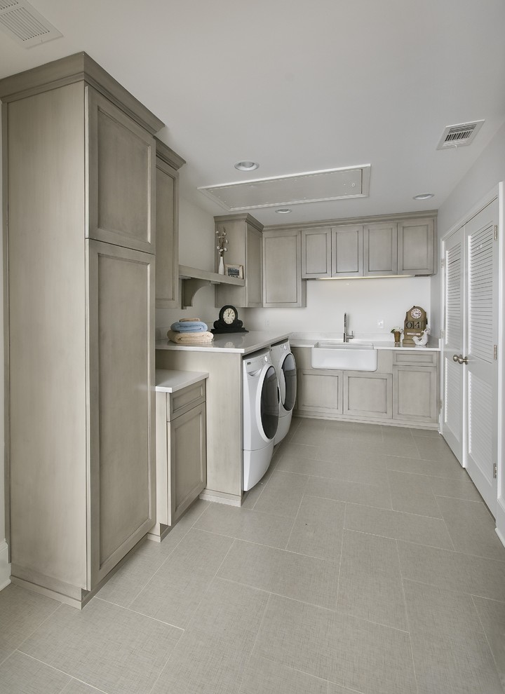 Photo of a large classic utility room in Atlanta with a belfast sink, grey cabinets, quartz worktops, white walls, a side by side washer and dryer and porcelain flooring.