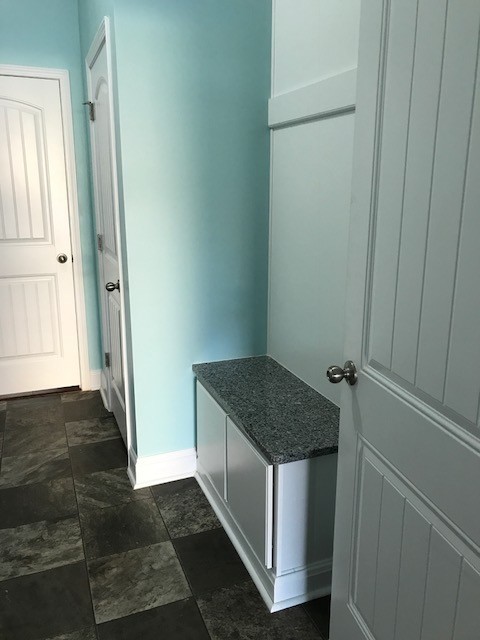 Ejemplo de lavadero multiusos y de galera tradicional de tamaño medio con armarios con paneles lisos, puertas de armario blancas, paredes azules, suelo laminado y suelo gris