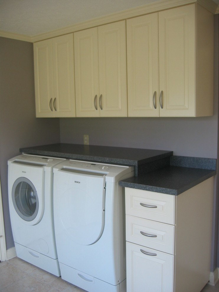 Inspiration for a medium sized classic single-wall separated utility room in Indianapolis with raised-panel cabinets, white cabinets, laminate countertops and a side by side washer and dryer.