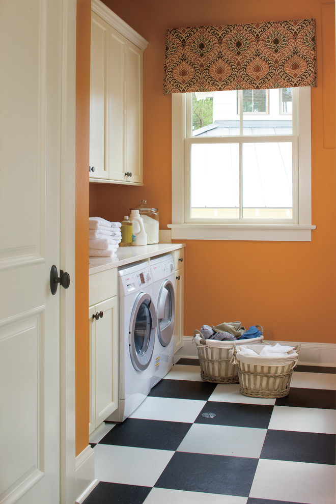 Klassischer Hauswirtschaftsraum mit oranger Wandfarbe, buntem Boden und weißer Arbeitsplatte in New Orleans