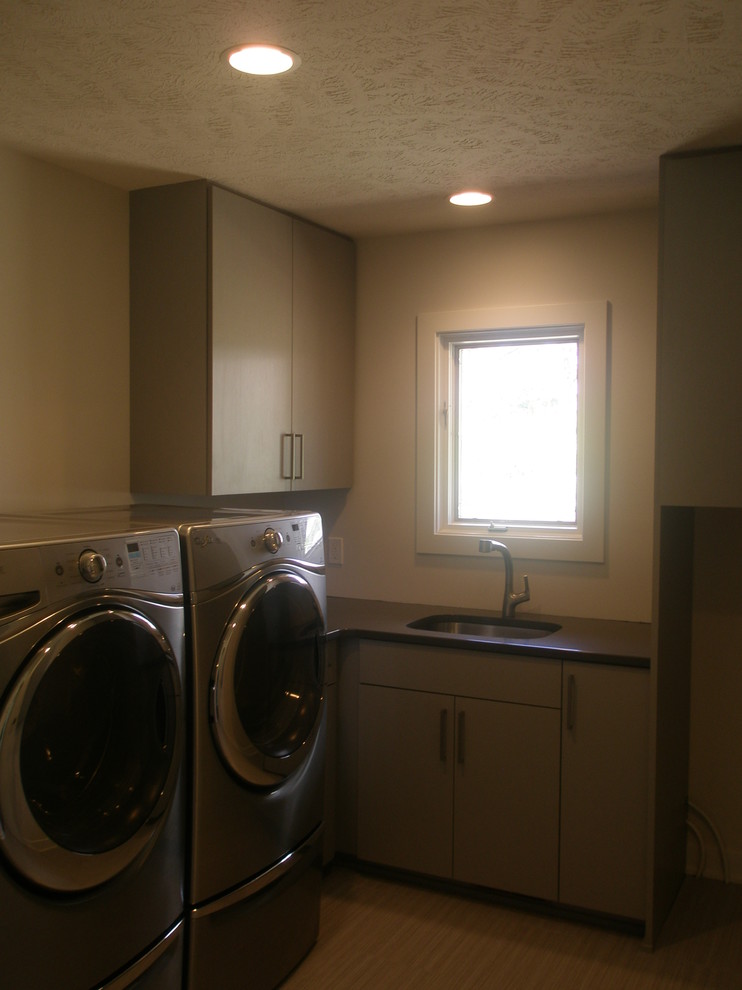 Esempio di una piccola sala lavanderia minimalista con lavello sottopiano, ante lisce, lavatrice e asciugatrice affiancate, ante beige, pareti beige e pavimento in vinile