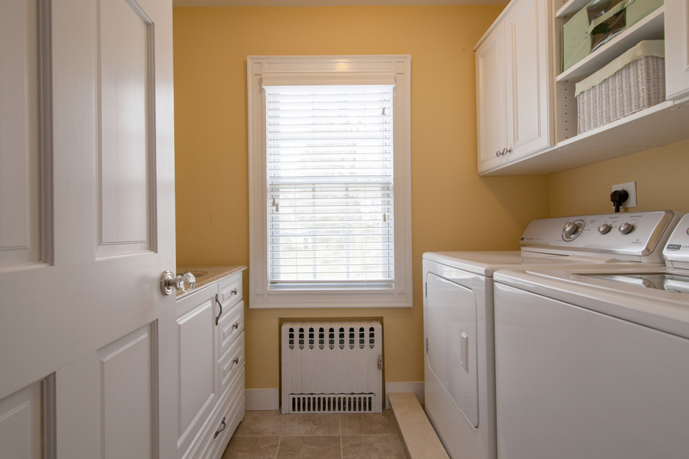 Idéer för en mellanstor klassisk parallell tvättstuga enbart för tvätt, med en undermonterad diskho, luckor med infälld panel, vita skåp, granitbänkskiva, orange väggar och en tvättmaskin och torktumlare bredvid varandra