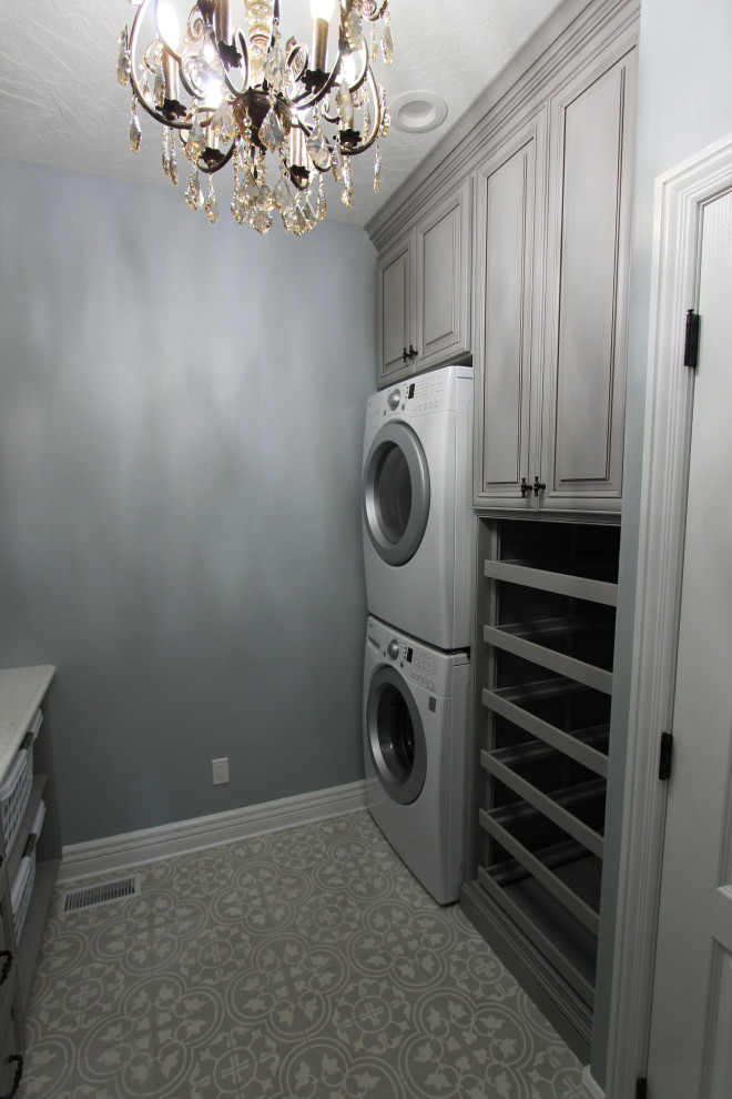 Inredning av en mellanstor flerfärgade parallell flerfärgat tvättstuga enbart för tvätt, med en undermonterad diskho, luckor med upphöjd panel, grå skåp, bänkskiva i kvartsit, flerfärgad stänkskydd, stänkskydd i marmor, grå väggar, betonggolv, en tvättpelare och grått golv